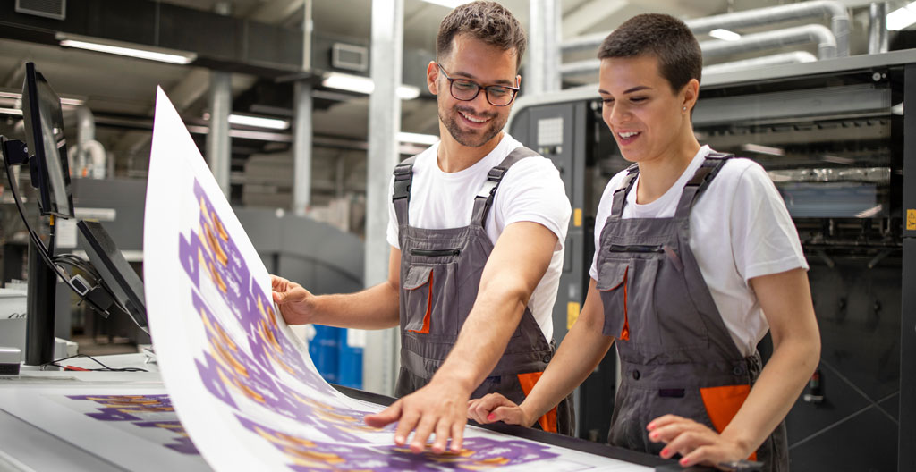 Imprimeur conseil en discussion avec une cliente autour d'échantillons dans un atelier toulousain
